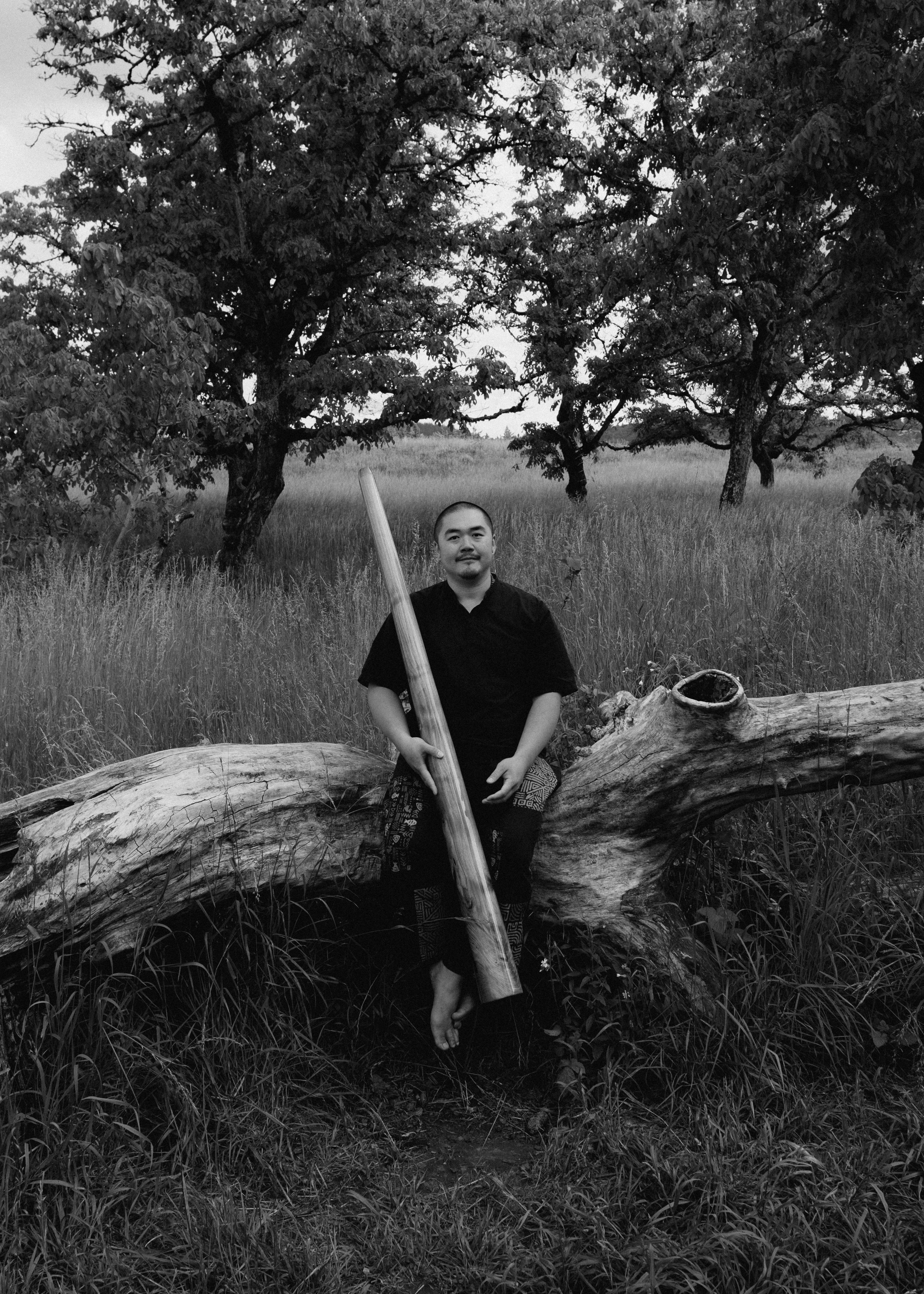 Jingfu with didgeridoo in a field